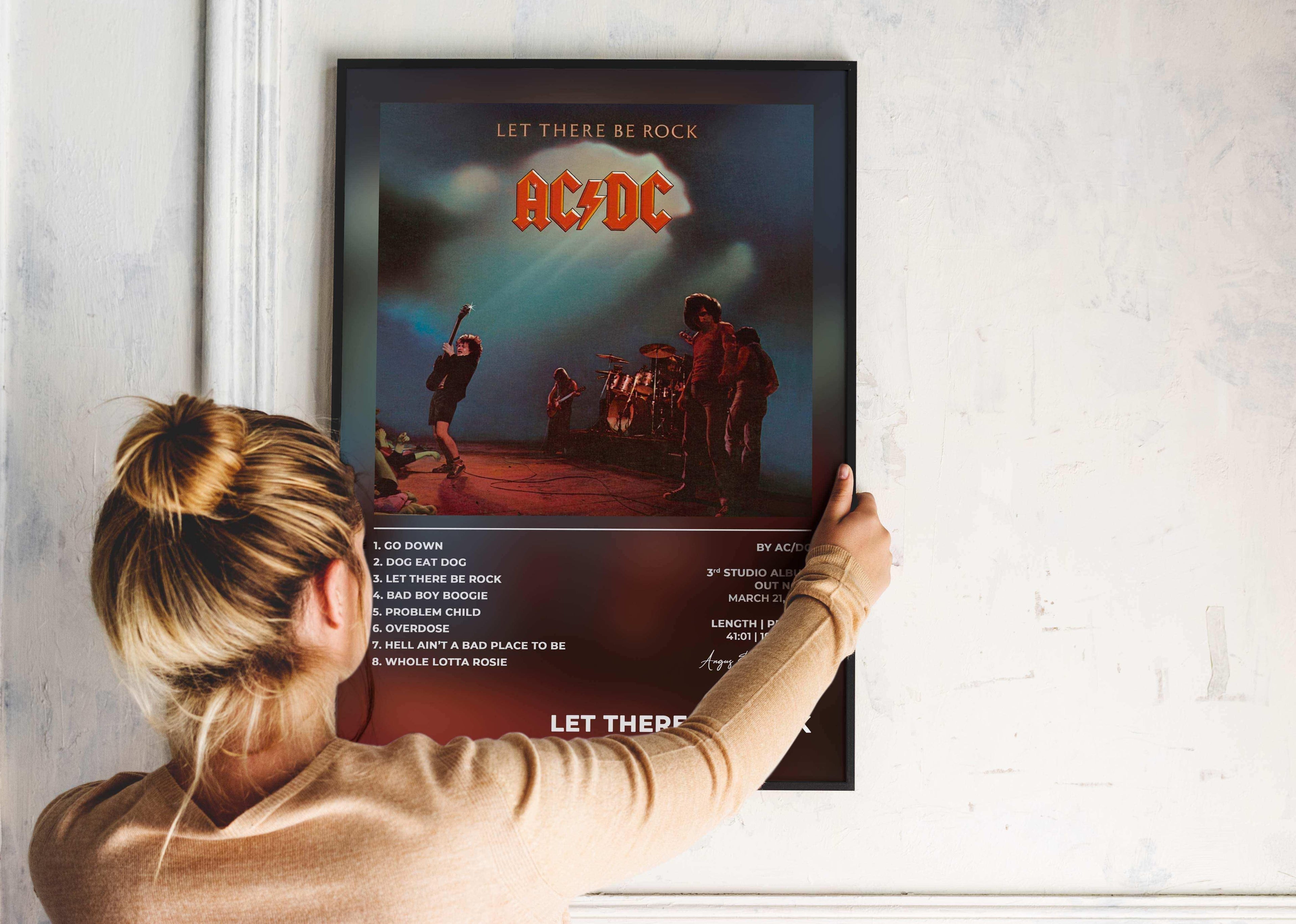 Affiche AC/DC Let There Be Rock accrochée par une femme, fait en France, livraison 48h gratuite, cadeau idéal Noël