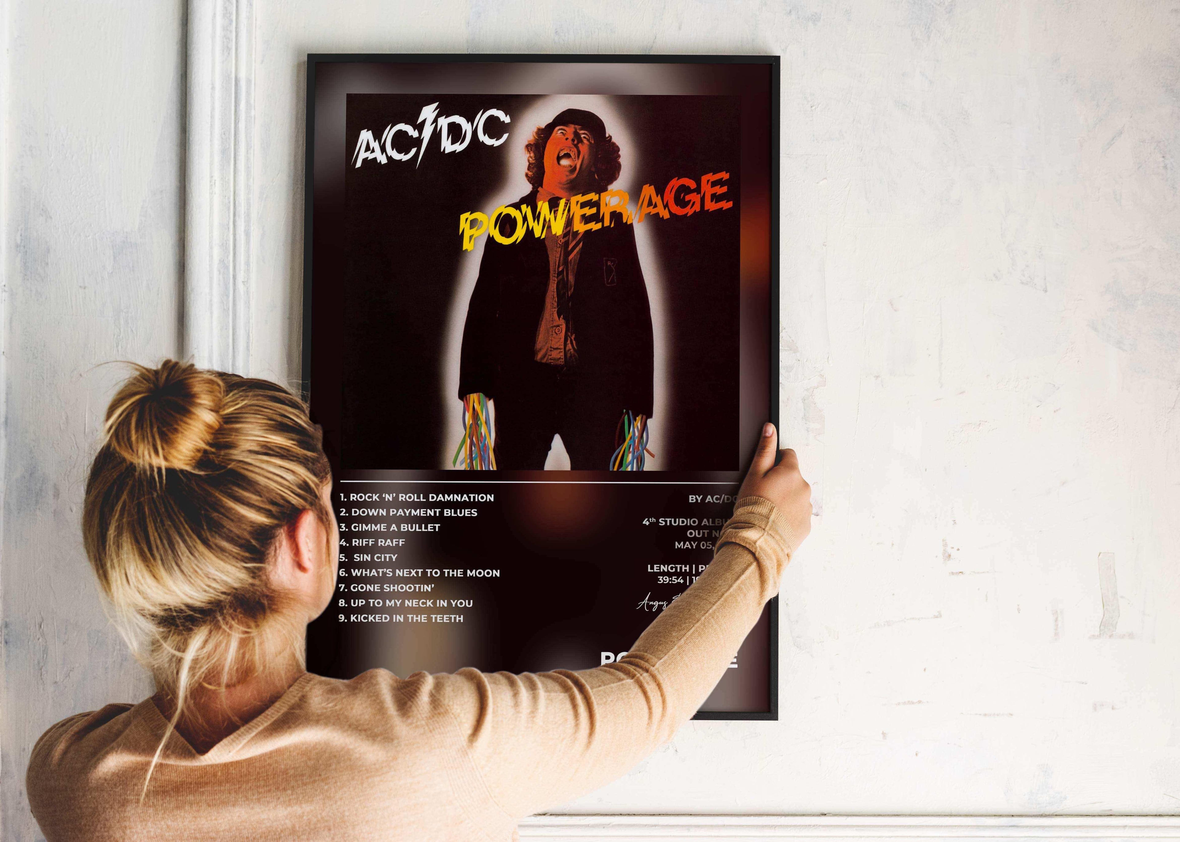 Femme accrochant un poster AC/DC Powerage, fait en France, livraison gratuite 48h, cadeau idéal Noël