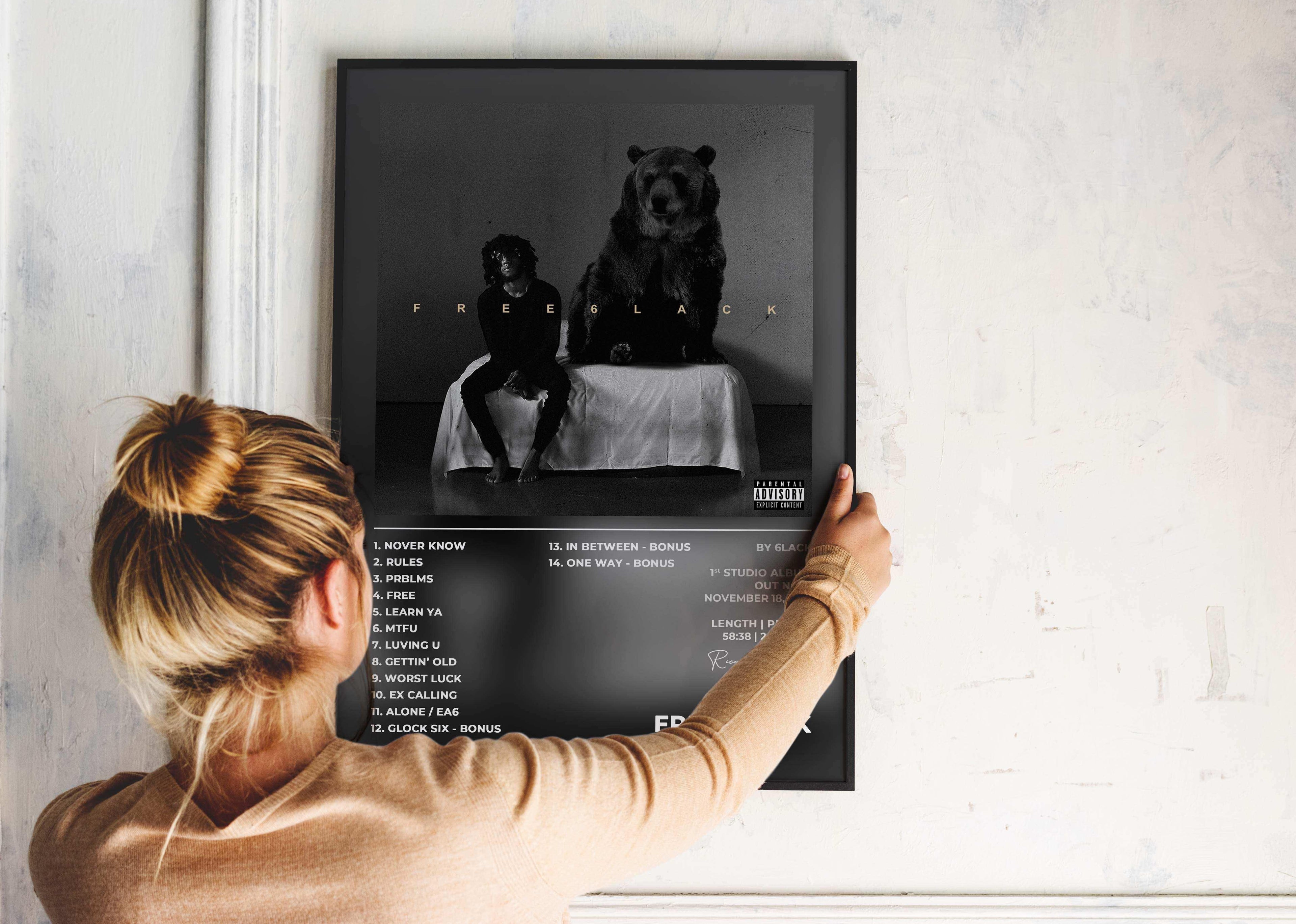 Femme accrochant une affiche noire sur un mur, fait en France, livraison 48h gratuite, cadeau idéal Noël