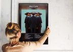 Une femme accroche un cadre photo murale avec pochette album "Multitude" de Stromae, fait en France, livraison gratuite 48h