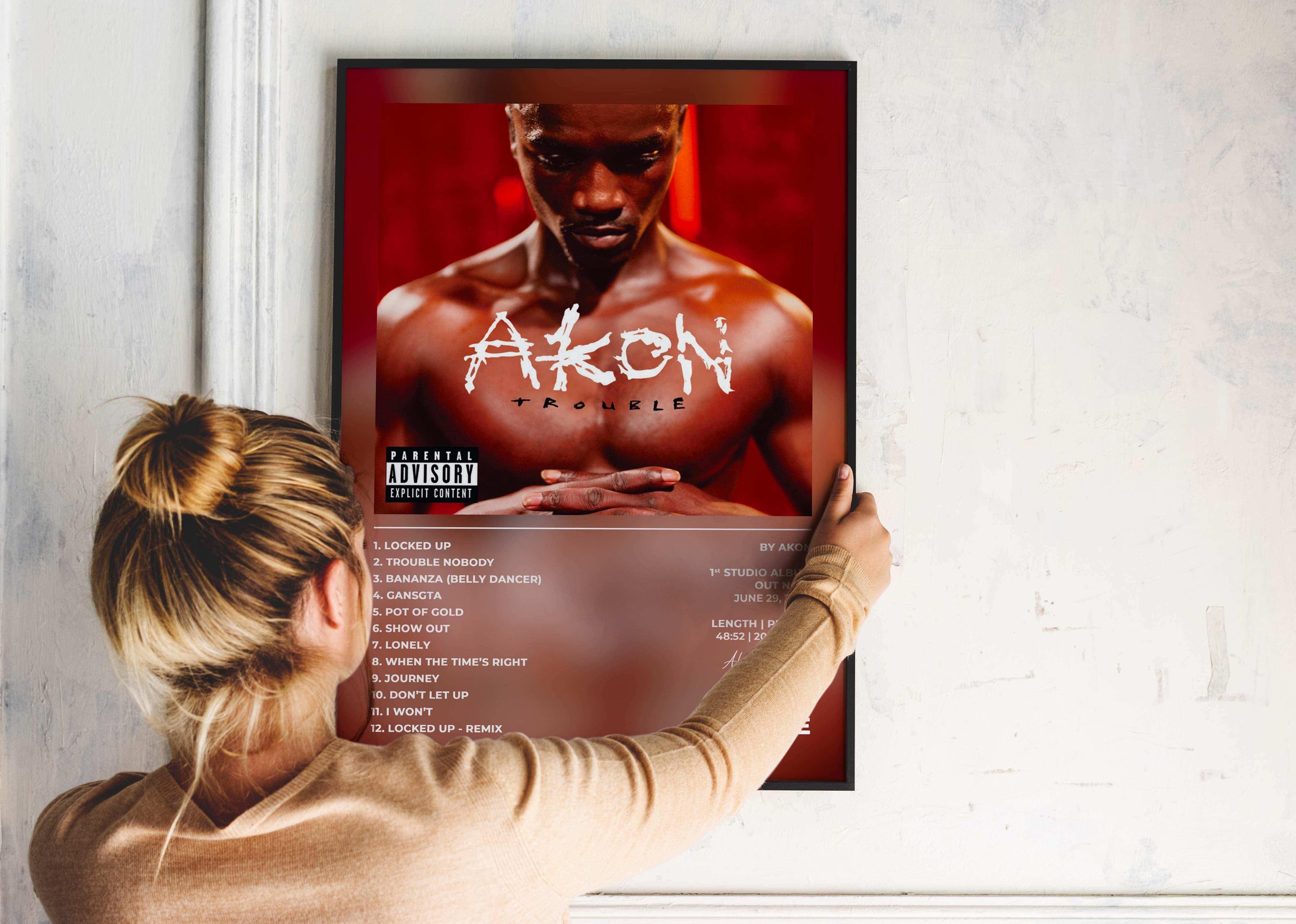 Femme accrochant un poster d'album Akon, fait en France, livraison gratuite 48h, cadeau Noël