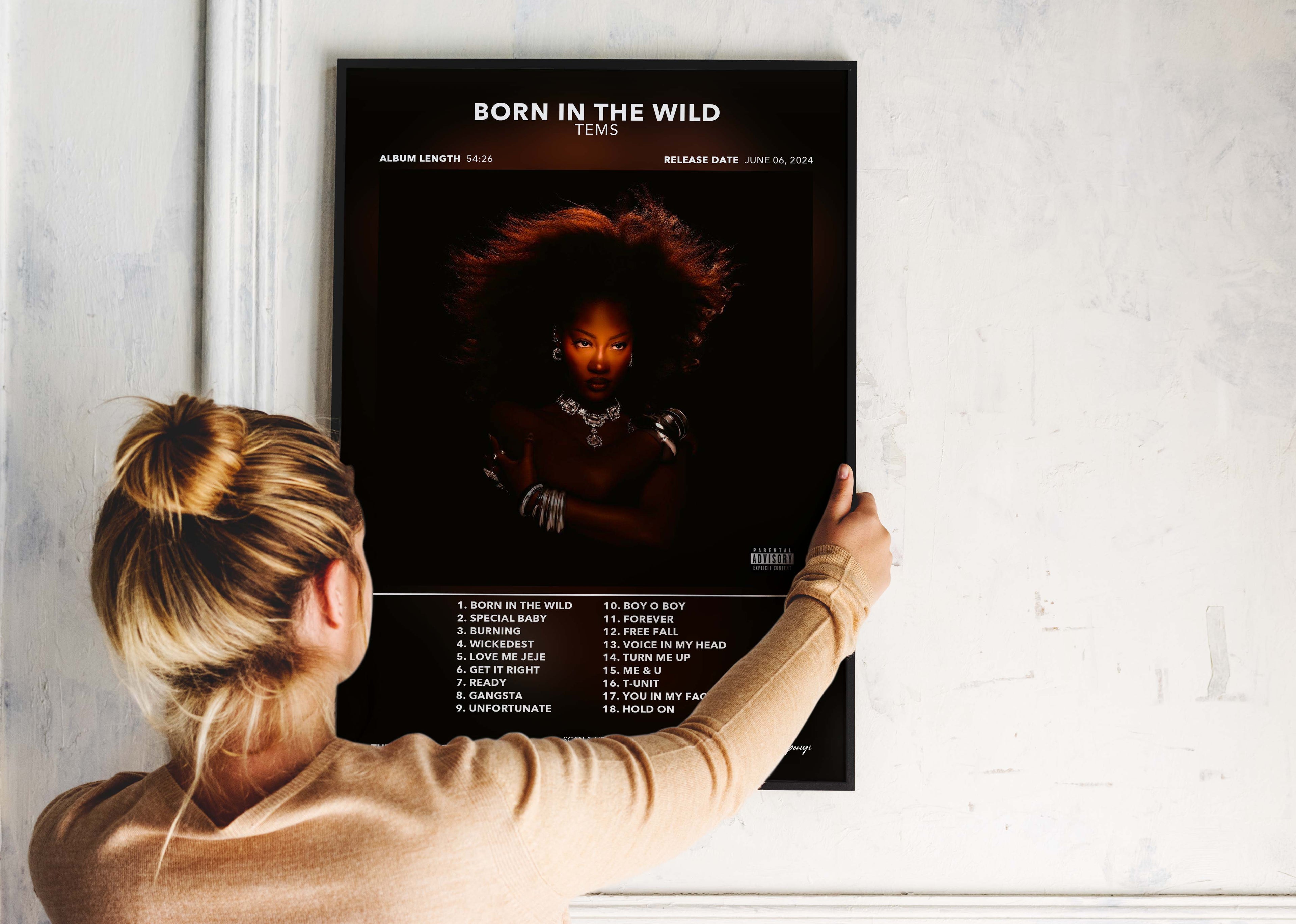 Femme accrochant affiche album Born in the Wild de Tems, fait en France, livraison gratuite 48h