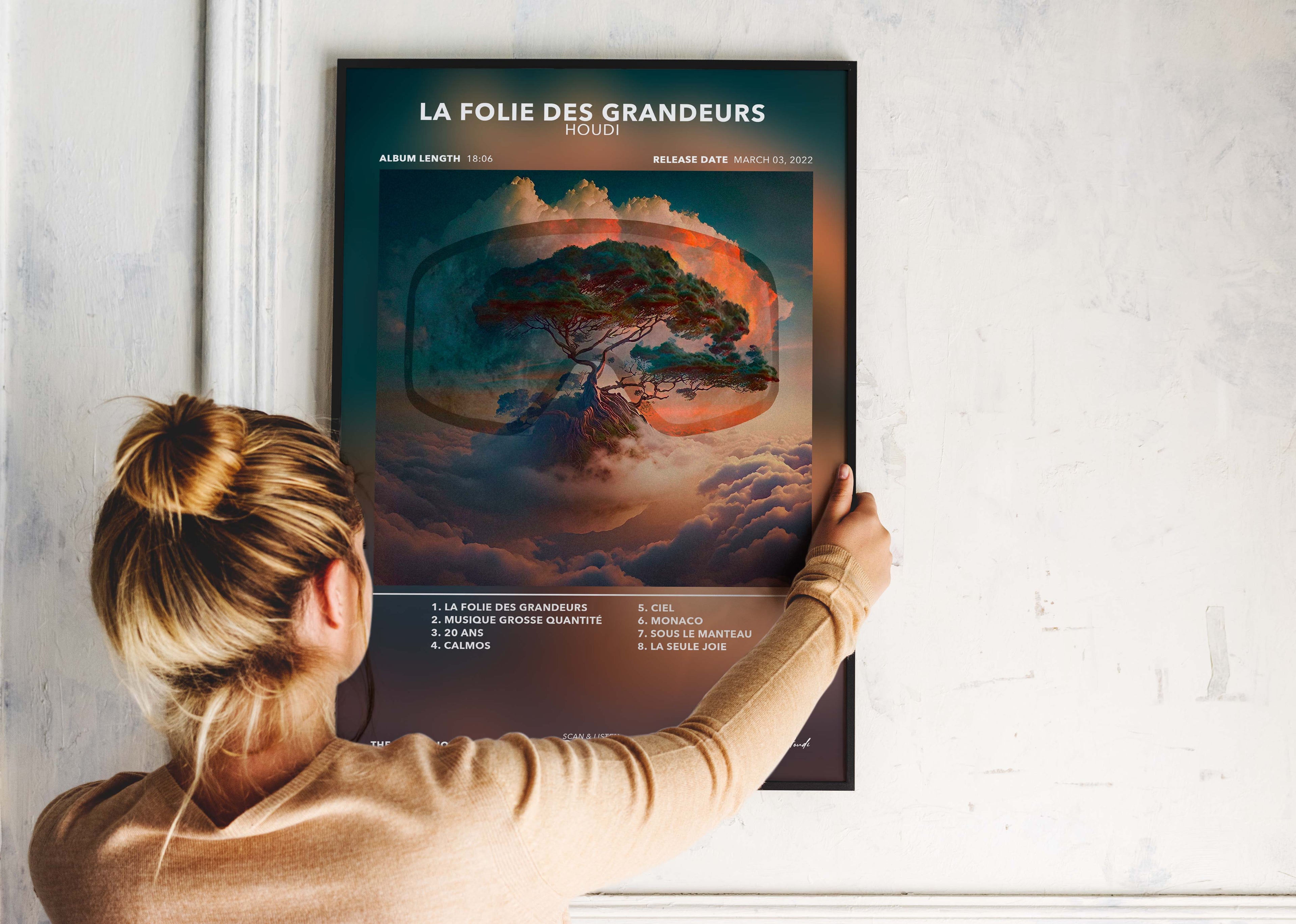 Femme accrochant un poster d'album musical "La Folie des Grandeurs" fait en France, livraison gratuite en 48h