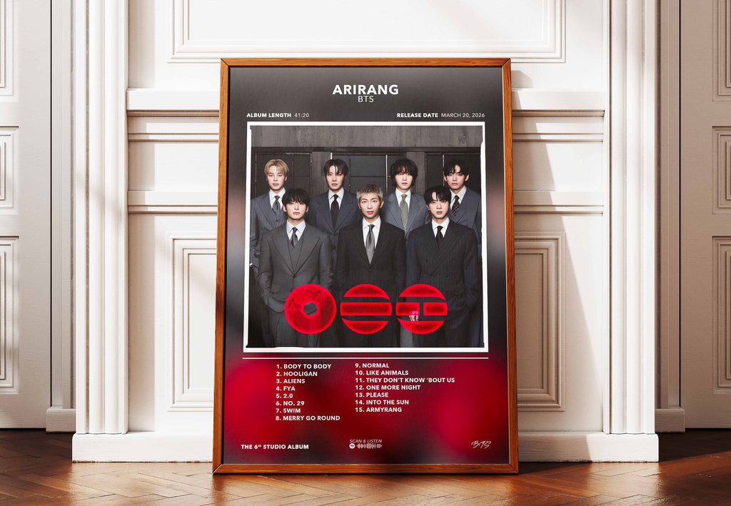Affiche encadrée de l'album Arirang de BTS marquant le retour du groupe après leur service militaire, posée contre un mur au style urbain.