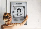 Une personne installe le poster encadré de Bruno Mars sur un mur de salon, montrant le rendu élégant de l'œuvre.