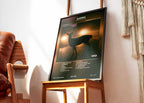 Portrait encadré de l'album Karma de Bigflo et Oli posé sur une chaise design dans une pièce lumineuse.