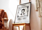 Cadre contenant l'affiche de Bruno Mars "The Romantic" posé sur une chaise design dans un intérieur chic et lumineux.