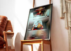 Cadre photo contenant l'affiche de PLK Grand Cru posé sur une chaise dans un salon au design contemporain.